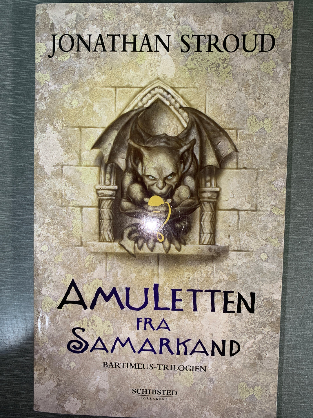 Jonathan Stroud. 2004. Amuletten fra Samarkand. Bok.
