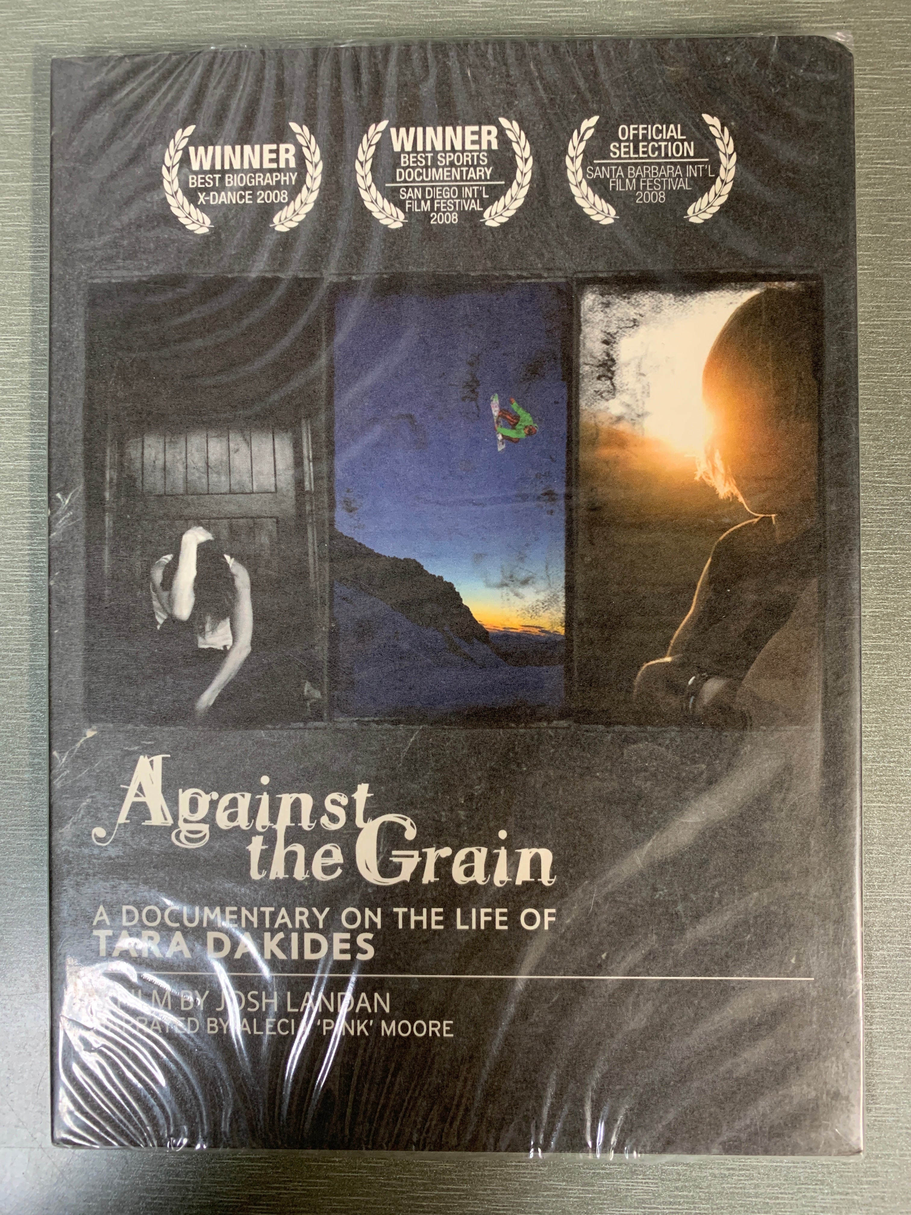 Against the Grain: A Documentary on the Life of Tara Dakides (2008). DVD. Ny i plast!