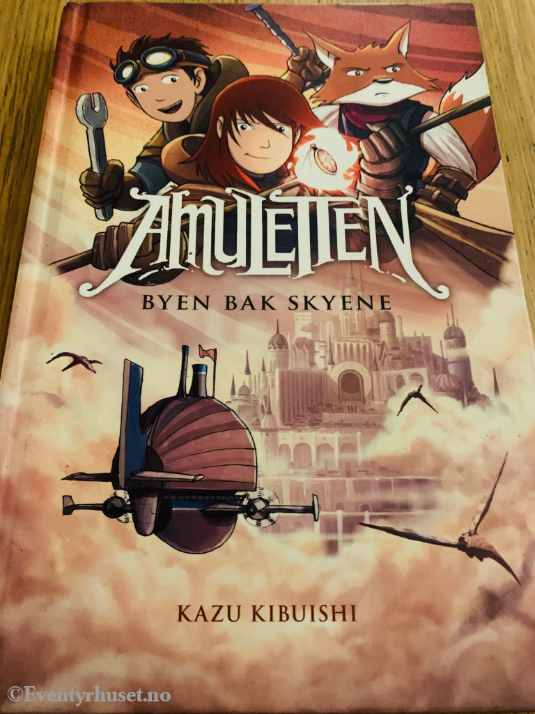 Kazu Kibuishi. 2012. Amuletten: Byen bak skyene. Bok. Walt Disney Home Video
